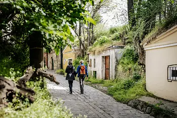 Two women walk past wine cellars