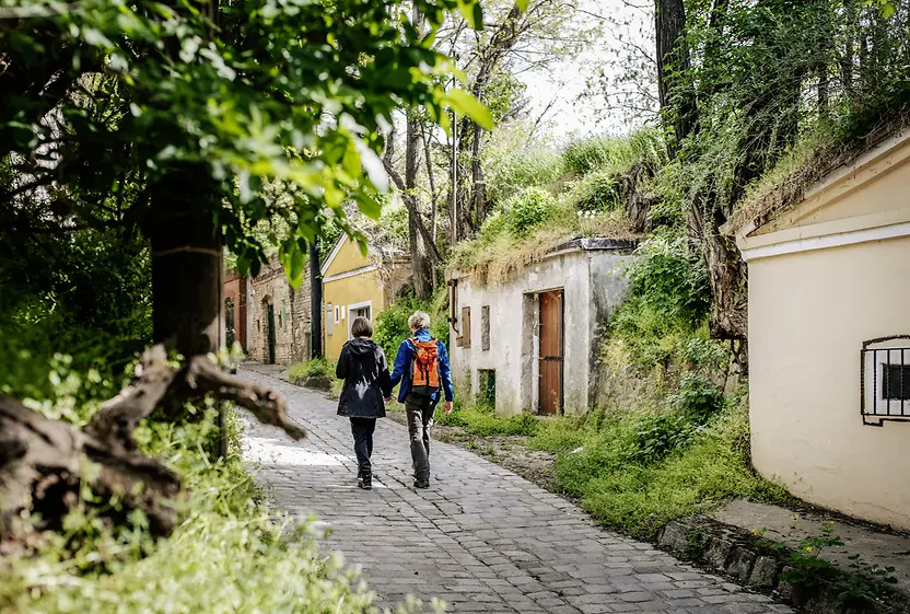 Two women walk past wine cellars