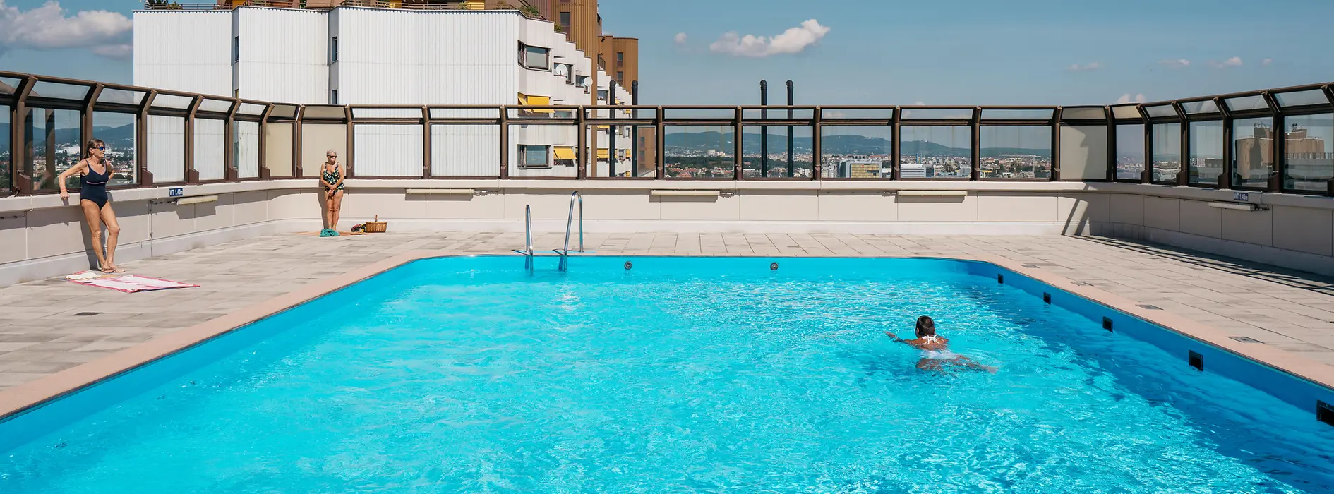Alterlaa, outdoor pool on the roof, people swimming on a sunny day