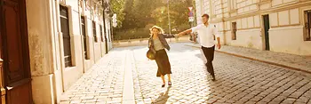 Couple walking in the old town, green area in the background