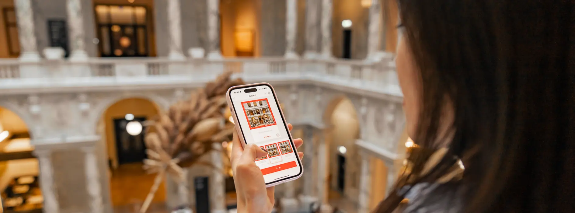 Dark-haired lady looking at the display of her smartphone.