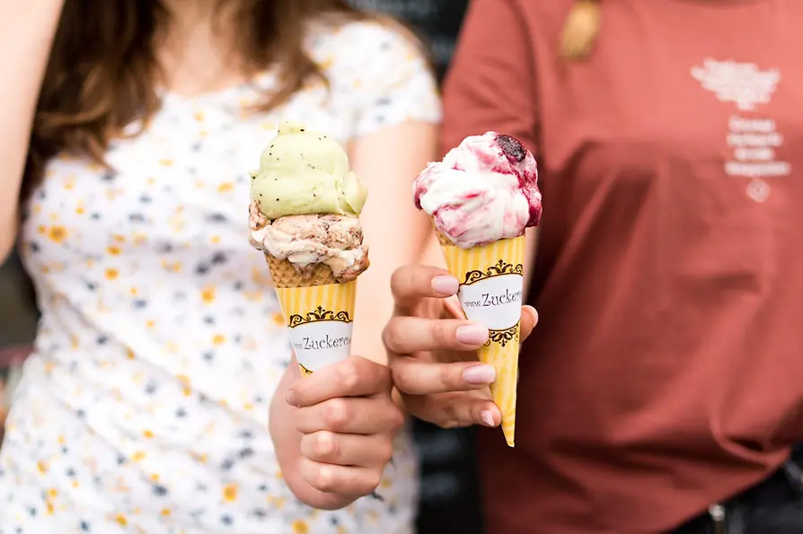 Two people are holding ice cream cones
